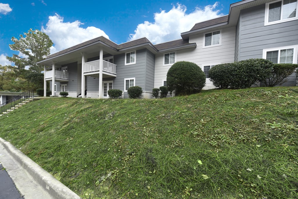 the view of an apartment building with a grassy lawn