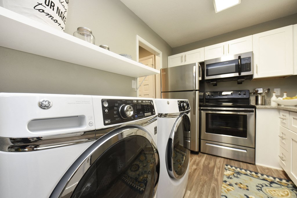 a laundry room with a washer and dryer and a stainless steel refrigerator