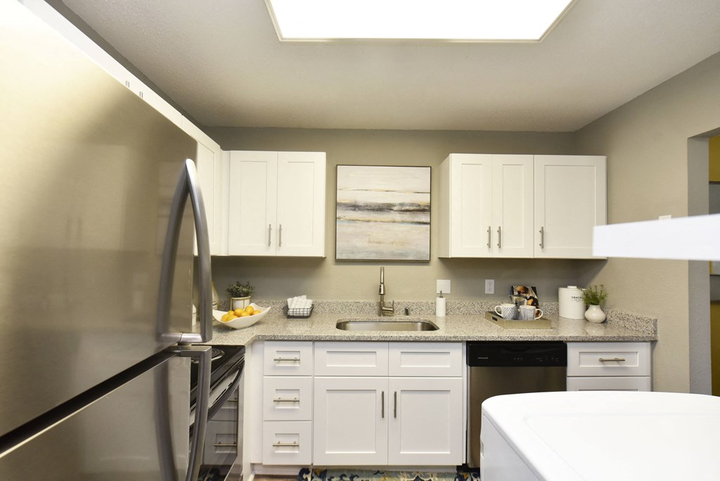 a kitchen with white cabinets and a counter top and a sink