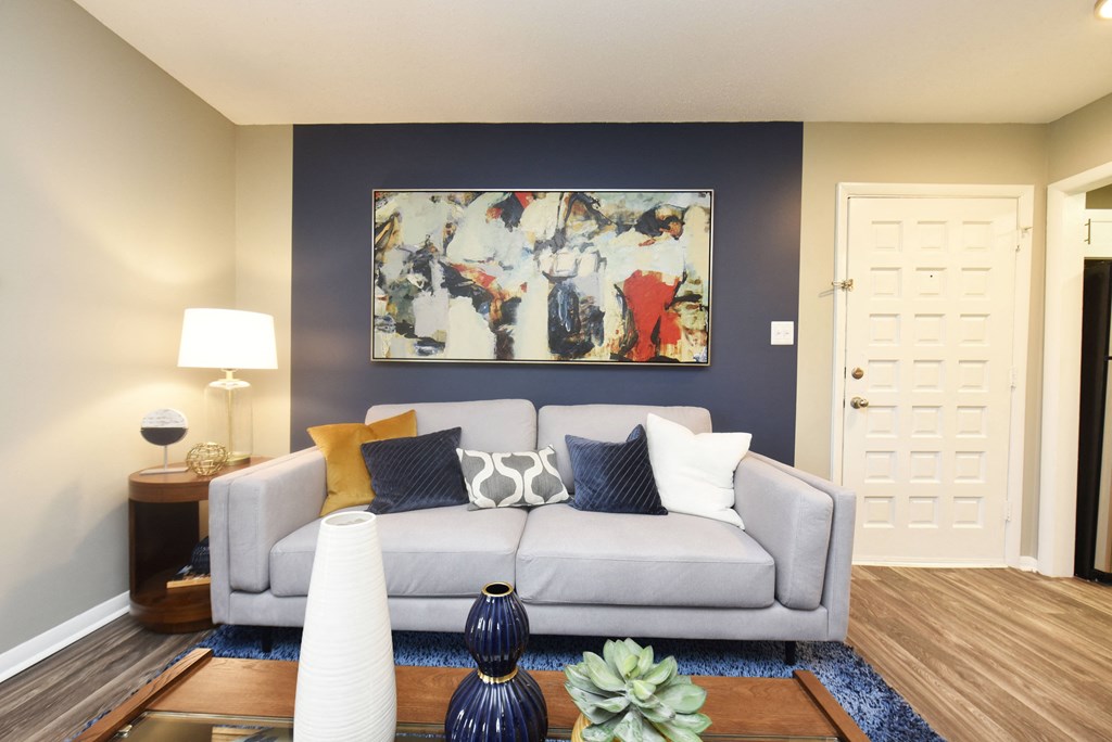 a living room with a couch and a painting on the wall