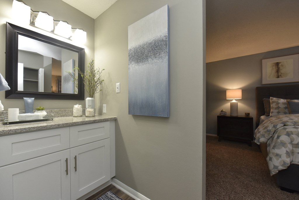 a bedroom with a sink and a mirror and a bed