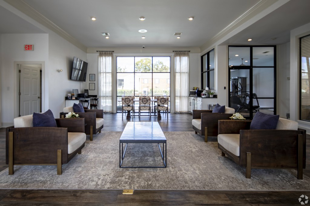 A spacious living room with a central coffee table and multiple seating options.