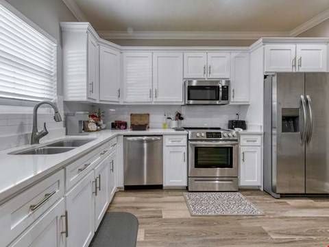 A kitchen with white cabinets and stainless steel appliances.