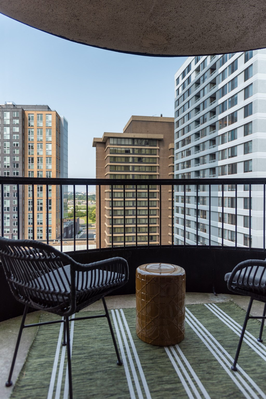 a balcony with chairs and a table and a view of skyscrapers