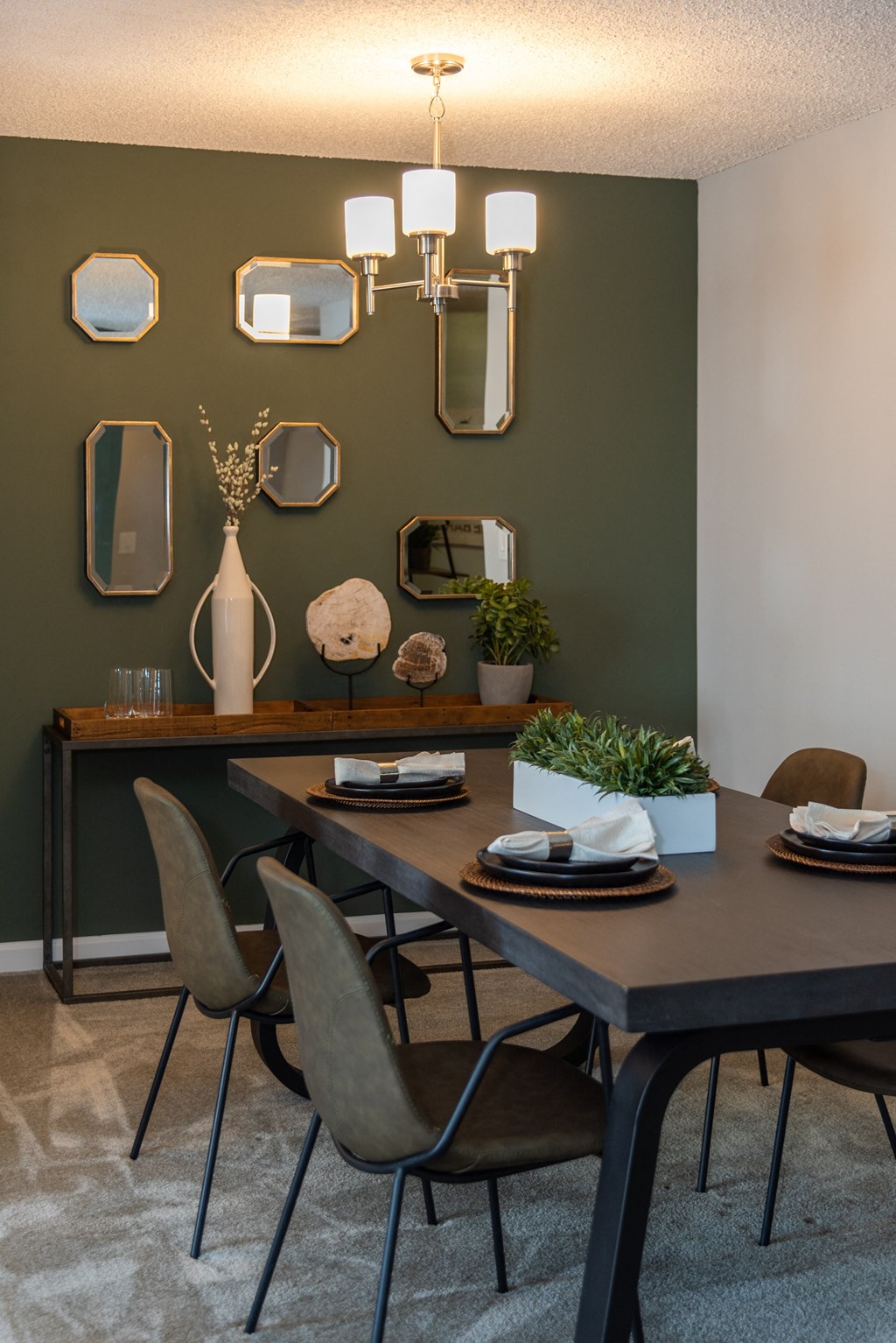 a dining room with a table and chairs and mirrors on the wall