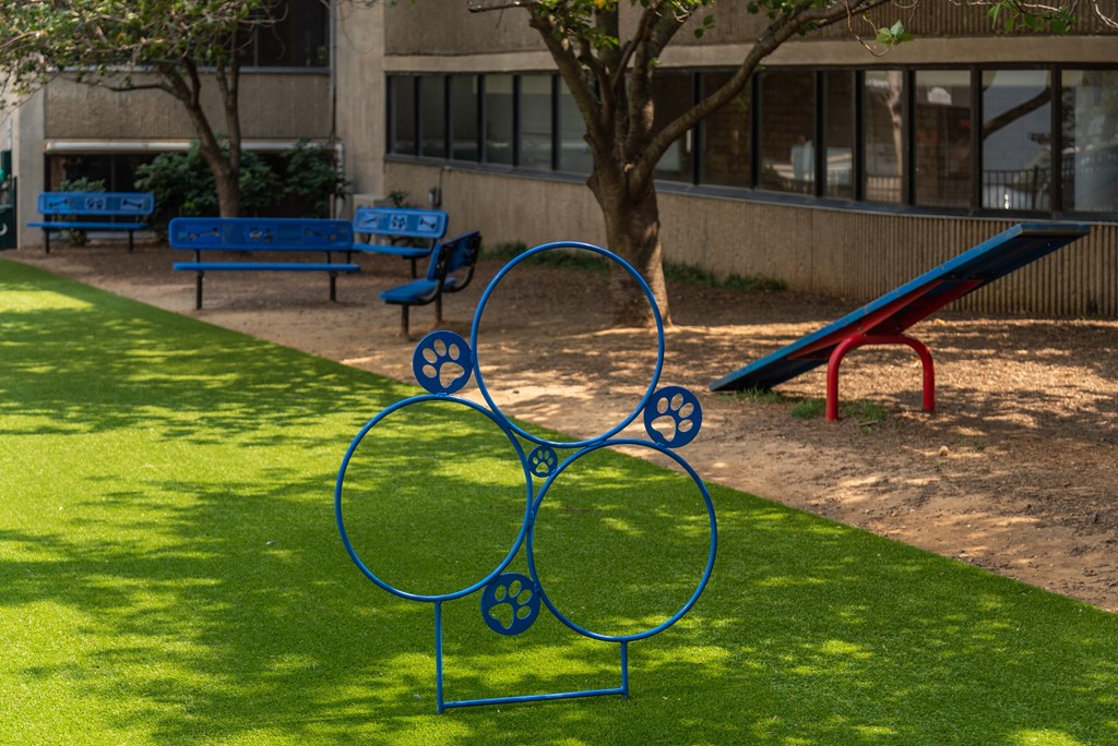 a blue sculpture in the shape of a bike in a park