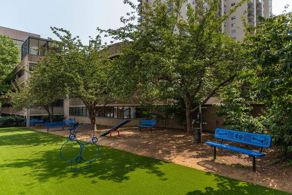 a park with benches and trees in front of a building