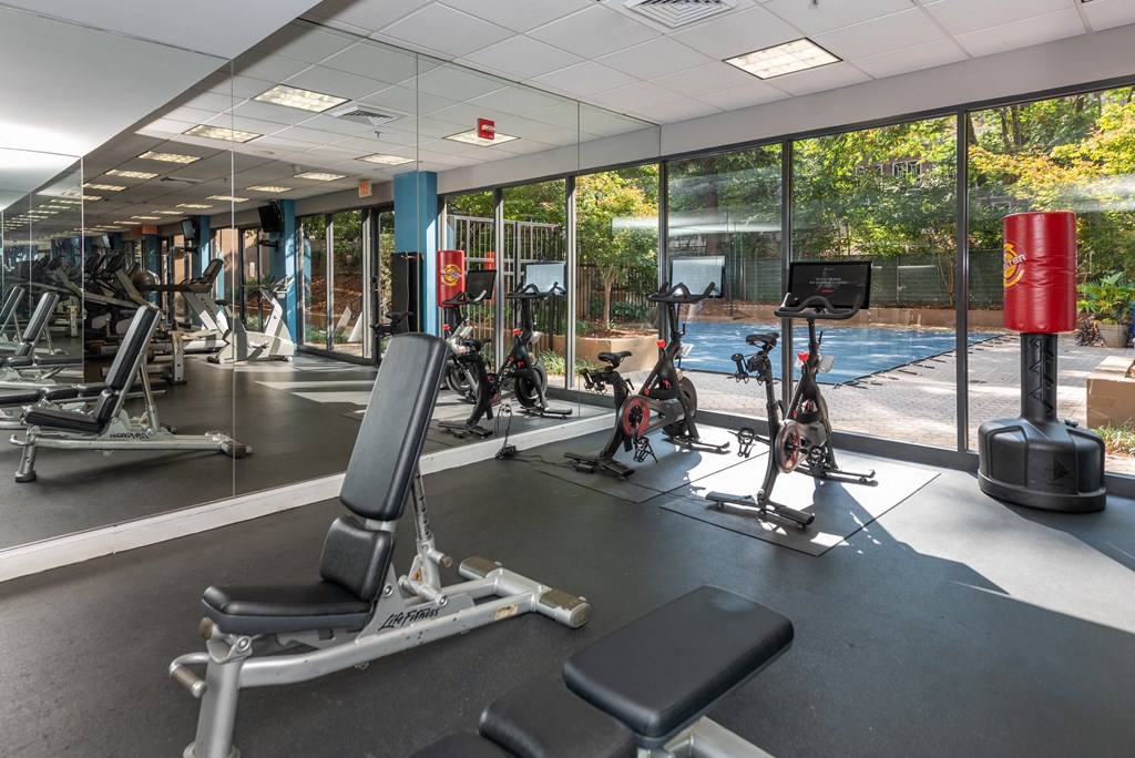 a gym with weights and cardio equipment in a building with glass windows