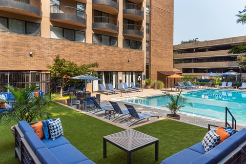 a swimming pool with lounge chairs and a building in the background