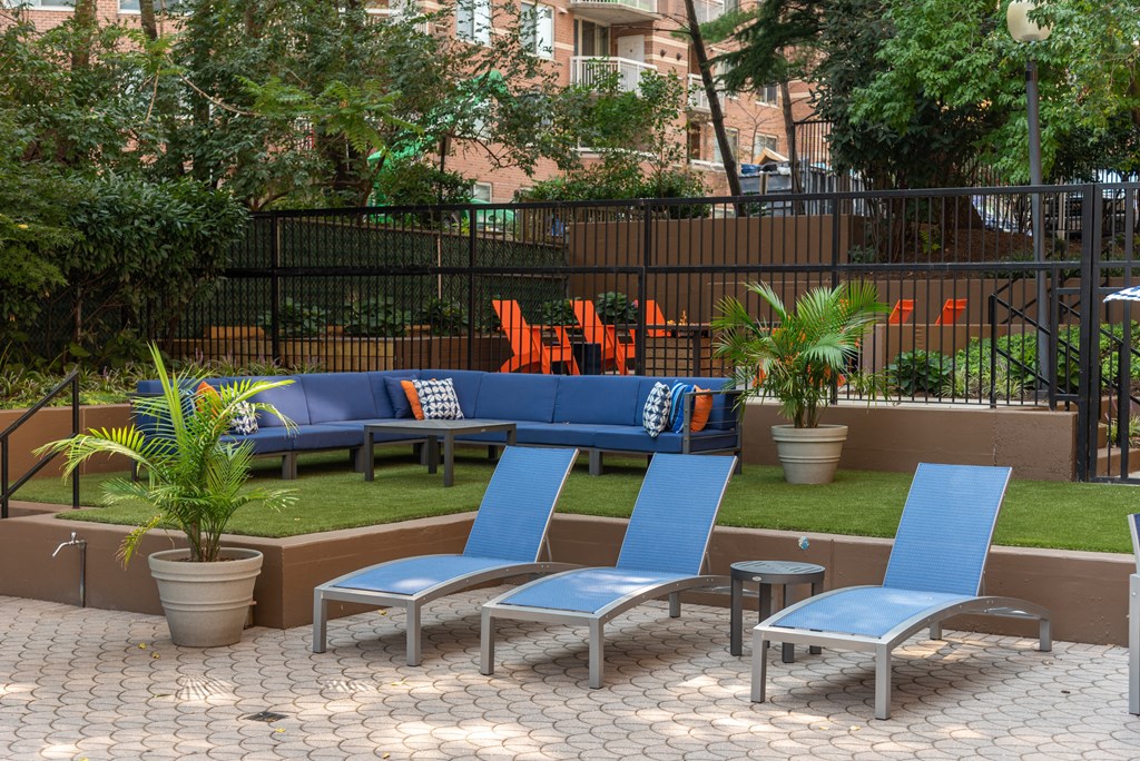 a seating area with blue chairs and a lawn