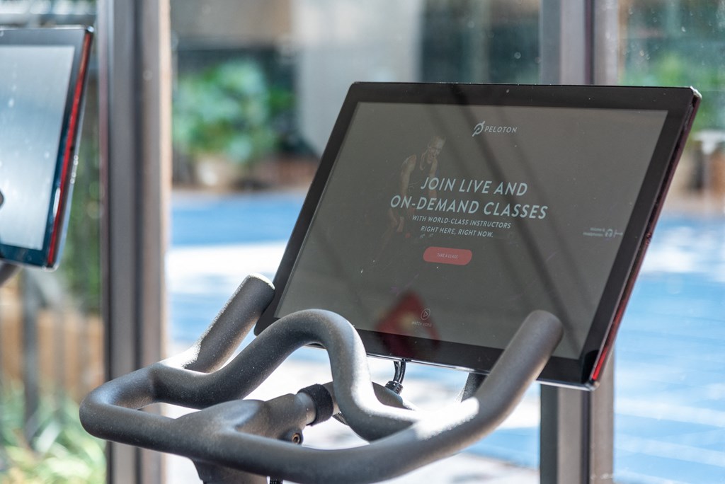 a computer screen sitting on a chair in front of a glass door
