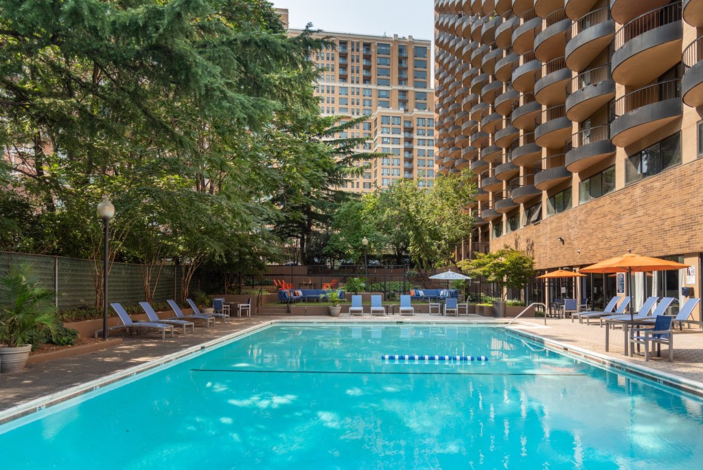 a swimming pool at a hotel with a building in the background