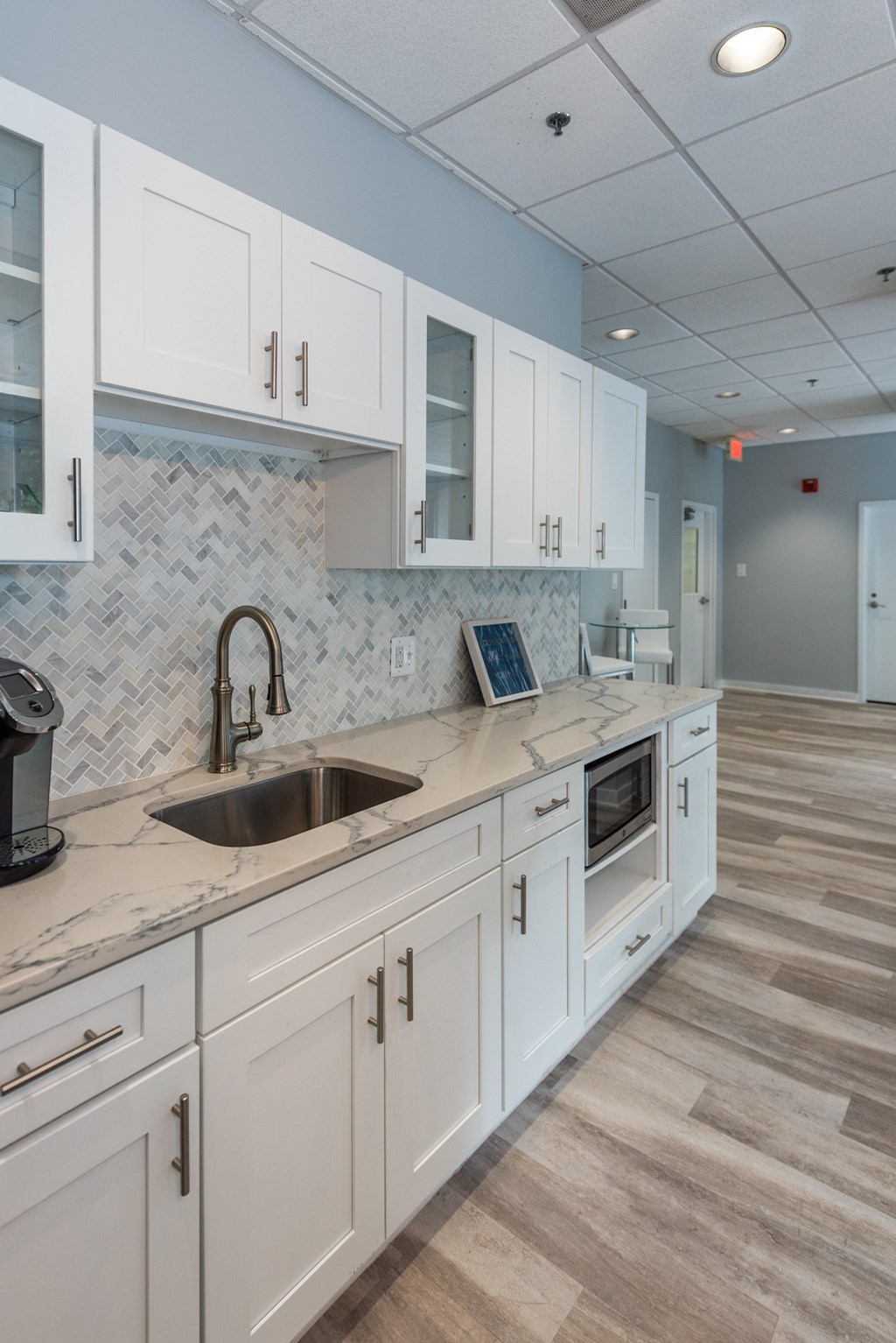 a large kitchen with white cabinets and a sink