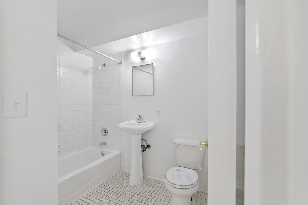 a white bathroom with a toilet sink and tub