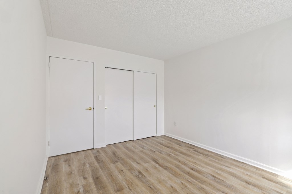 an empty room with white walls and wooden floors
