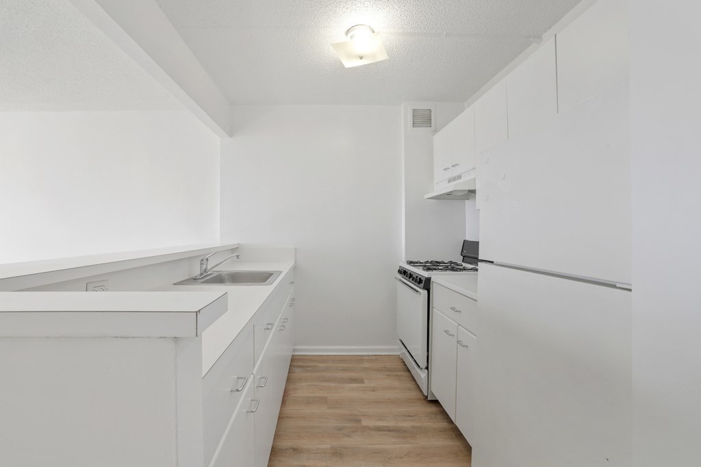 a white kitchen with white appliances and white cabinets