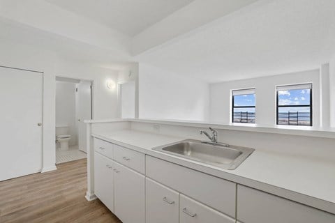 a kitchen with white cabinets and a stainless steel sink