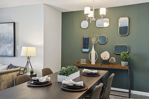 a dining room with a table and chairs and a wall with mirrors