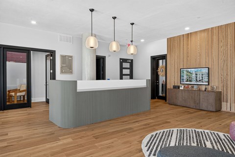 A reception area with a white counter and a wooden wall.