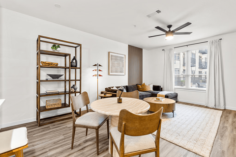 A living room with a round table and chairs.