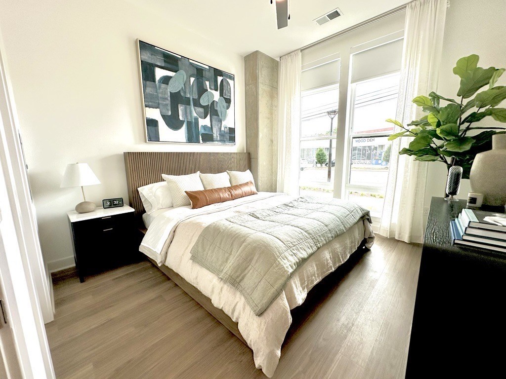 A bedroom with a large bed and a painting on the wall.