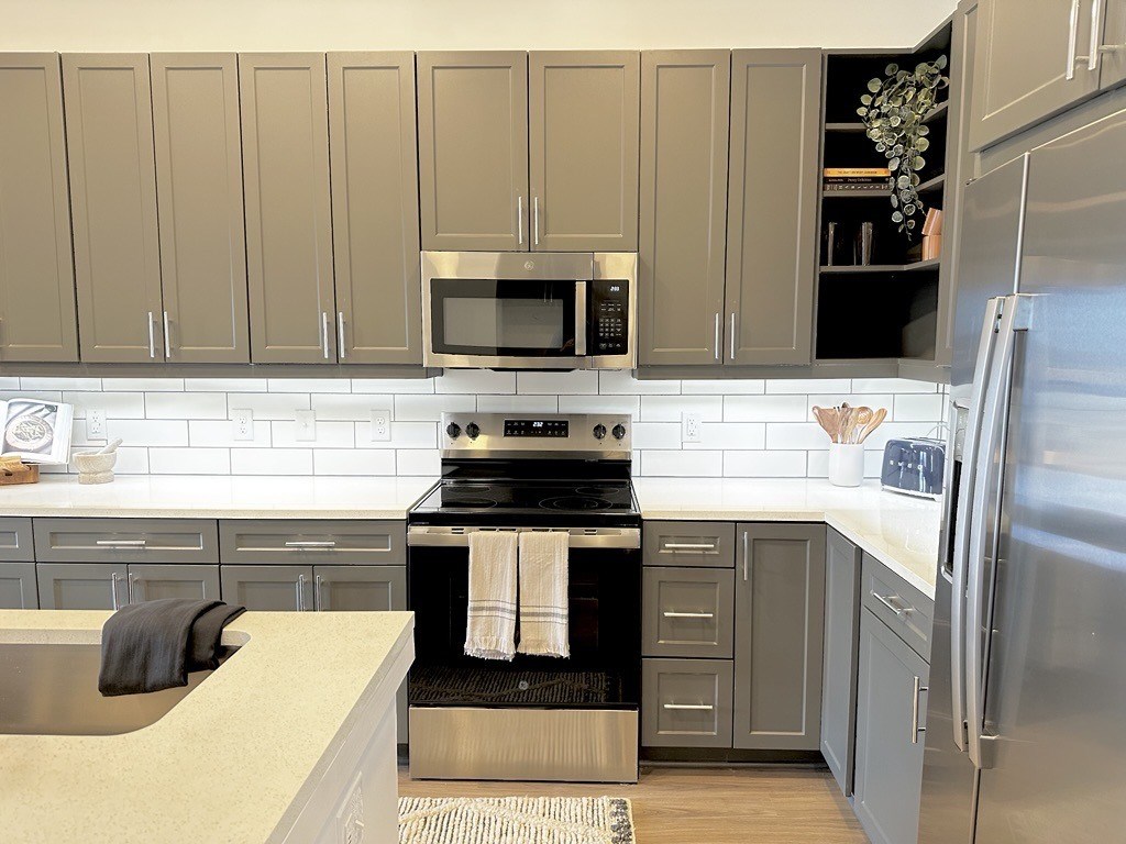 A kitchen with a stove top oven and a microwave above it.