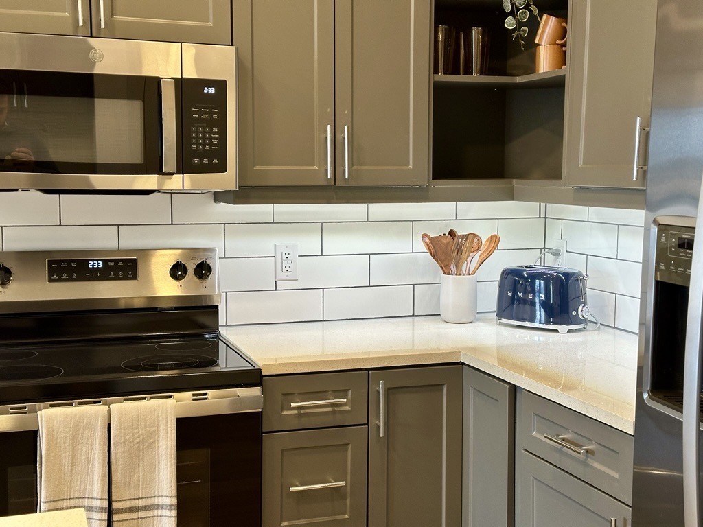 A kitchen with a stove, microwave, and oven.