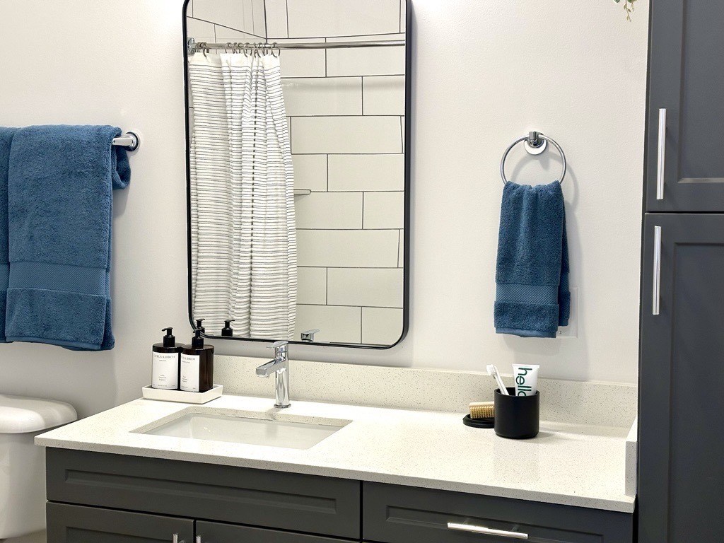 A bathroom with a white sink and a blue towel hanging on the wall.