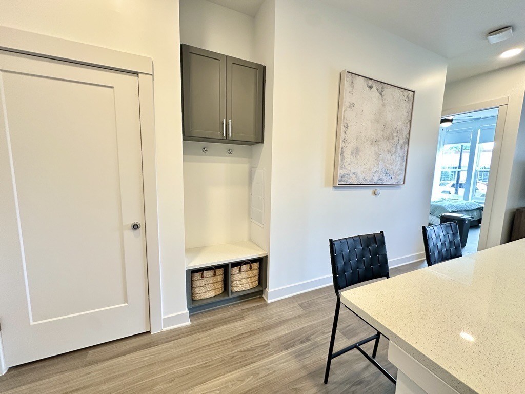 A kitchen with a white counter top and a black chair.