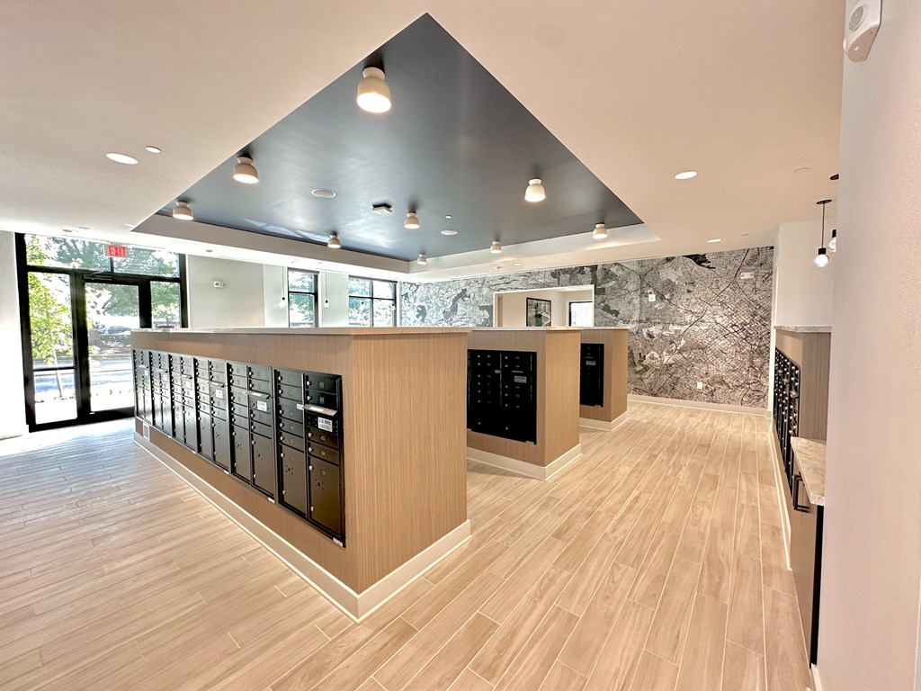 A modern kitchen with wooden floors and a large island with black appliances.