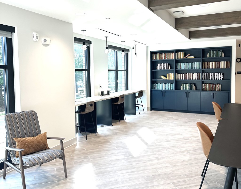 A room with a chair and a table with a pillow on it.