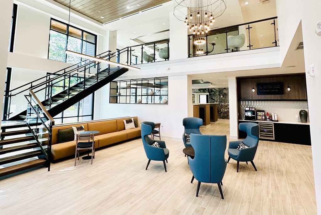 A spacious living room with a staircase and a bar area.