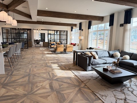 A spacious living room with a large patterned rug and a variety of seating options.