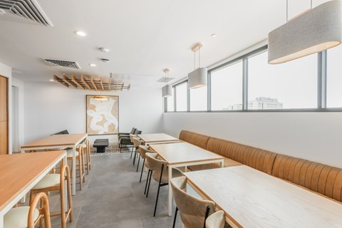 A modern dining area with wooden tables and chairs.