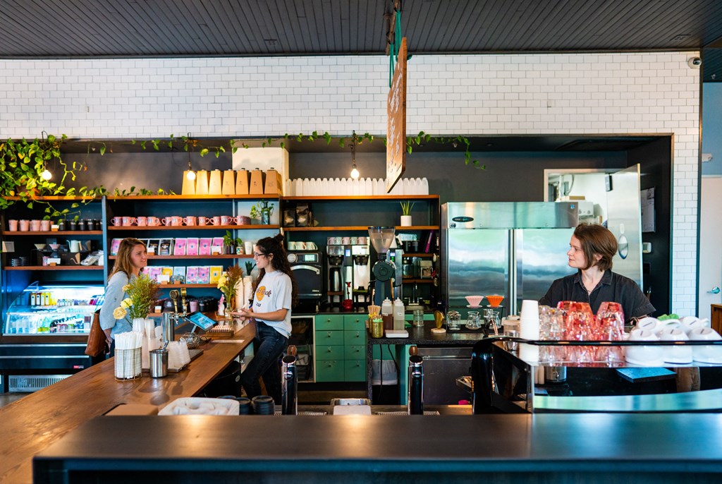A woman is standing behind a counter in a restaurant.
