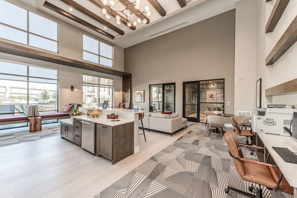 a kitchen and living room with large windows and a rug