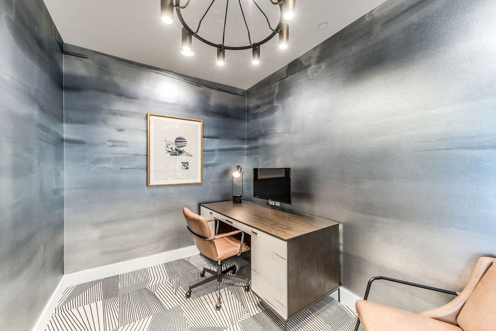 a home office with a large chandelier and a desk