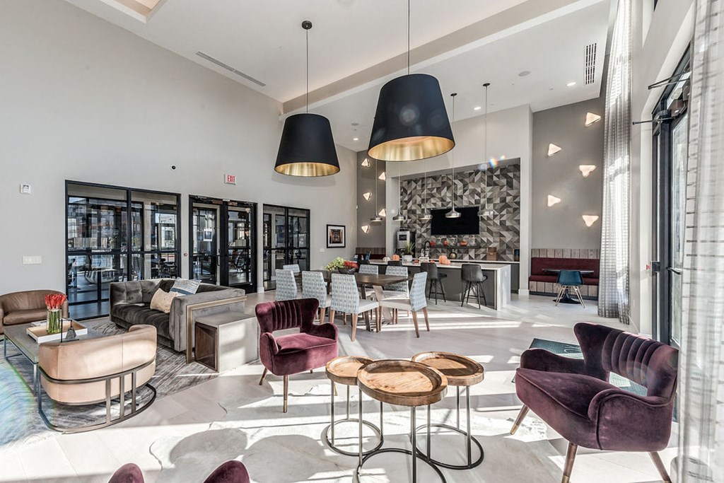 a lobby with chairs and tables and a tv