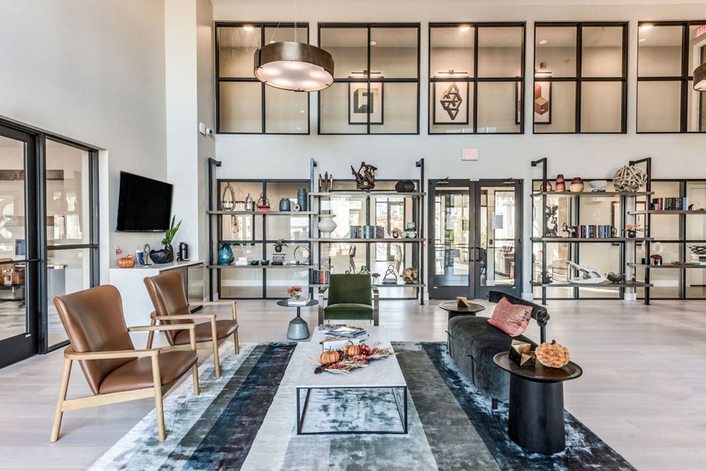 a living room with a couch and chairs and glass doors