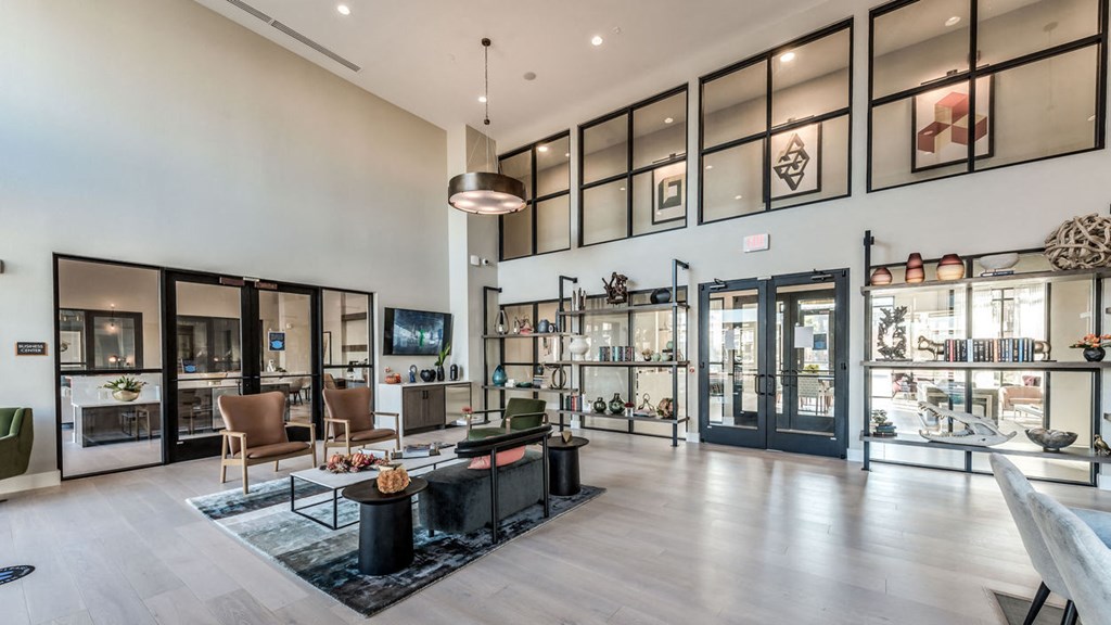 the lobby of a condo with a living room and glass doors