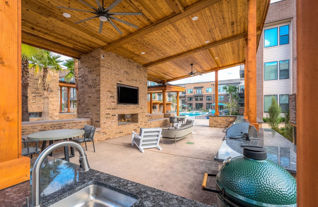 a patio with a sink and chairs and a fireplace