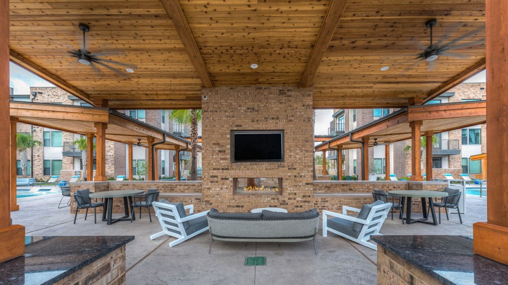 a patio with a fireplace and tables and chairs