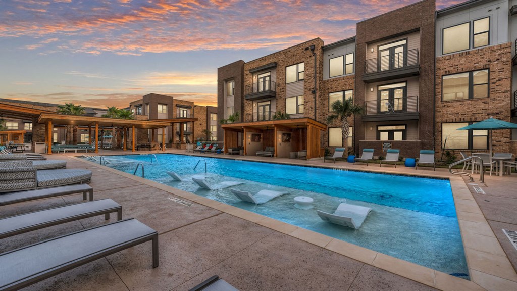 a large swimming pool in front of an apartment building