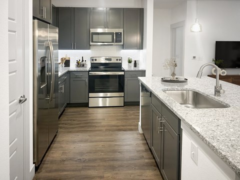 A modern kitchen with a stainless steel refrigerator and oven.