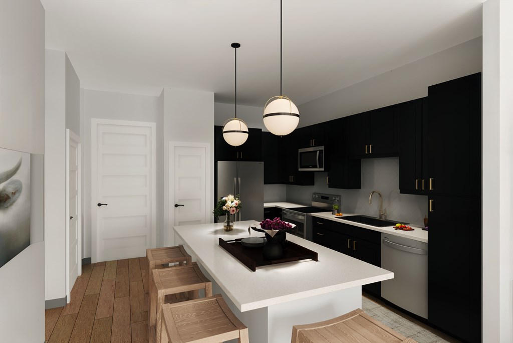 A modern kitchen with black cabinets and a white island.
