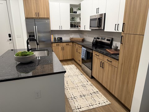 A kitchen with wooden cabinets and a black countertop.