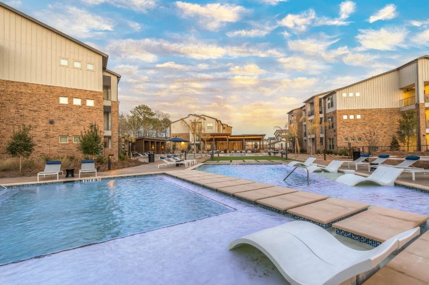 a swimming pool with lounge chairs next to a building