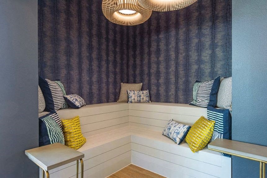 a small seating area with pillows and a blue and white wall