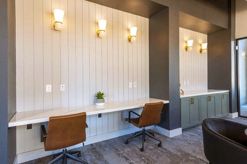 a desk with two chairs in a room with a mirror