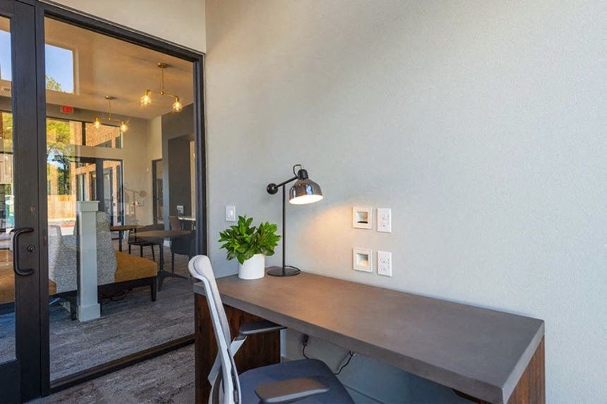 a desk with a lamp in a room with a sliding glass door